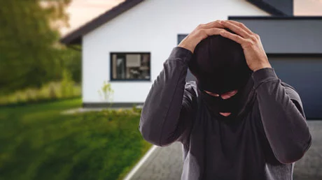 Einbrecher mit Händen überm Kopf geschlagen